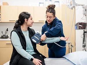 1月24日，密歇根州立大学丹佛分校的学生朱莉安娜·蒙托亚在奥瑞瑞亚健康中心检查一位病人的血压, 2024. 艾莉森·麦克拉伦摄